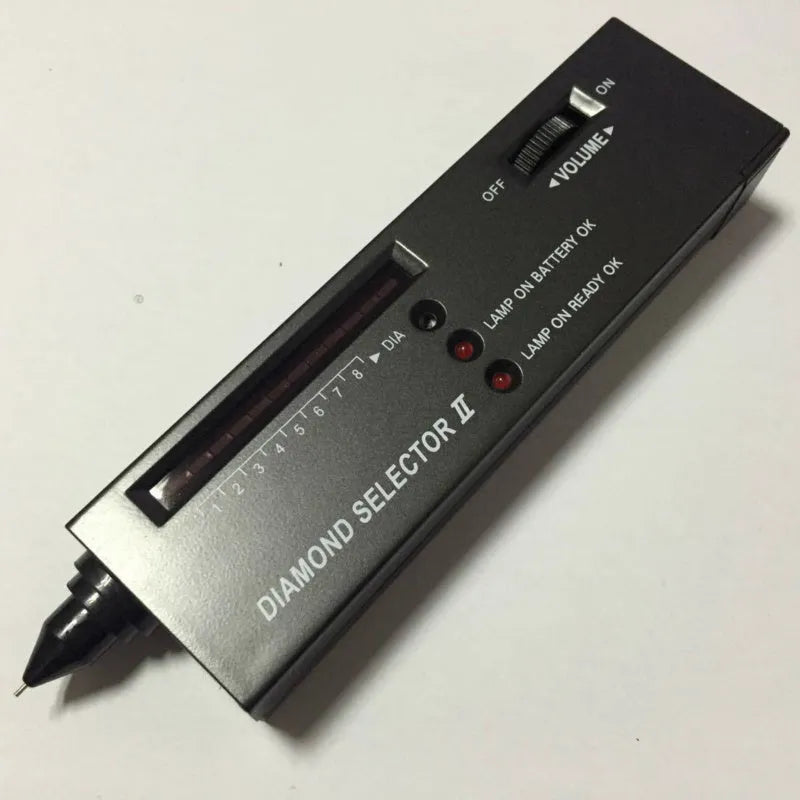 Black handheld diamond thermal conductivity tester with metal probe on a grey background.