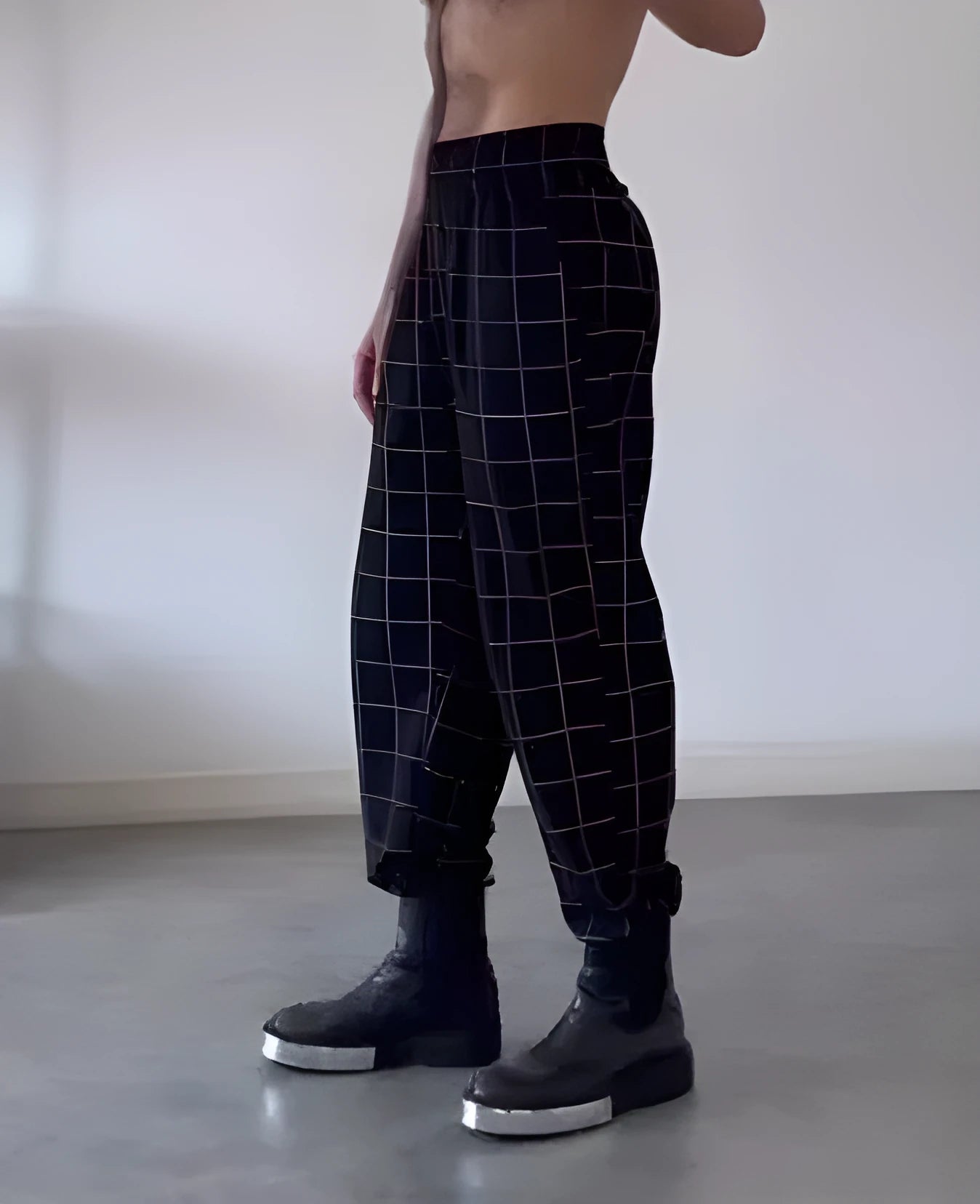 Men's plaid trousers featuring an apron-style front pocket panel in a tartan pattern.