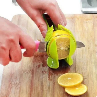 Green plastic fruit and vegetable cutting holder with slicing grid, measuring 18.5 cm.