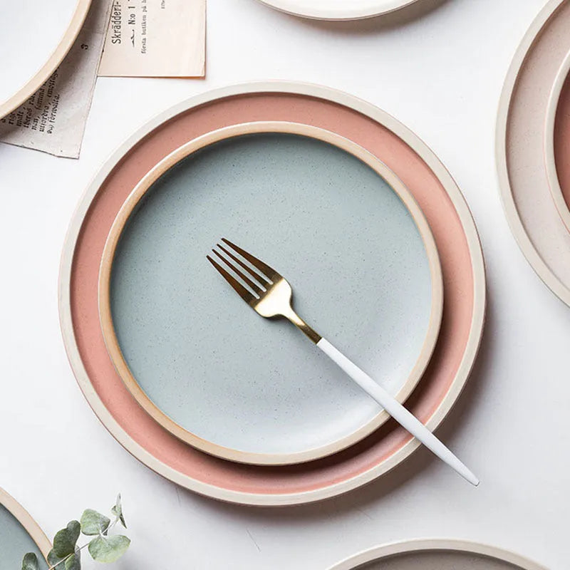 A 10-inch diameter pure blue matte ceramic dinner plate with a subtle textured finish on a wooden table.