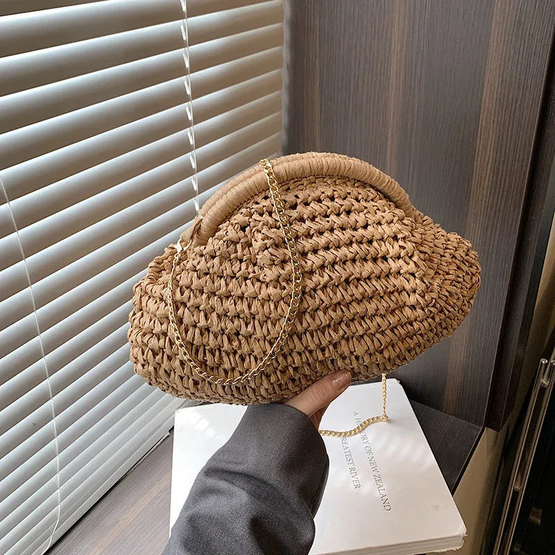 Women's khaki paper straw shoulder bag with a chain strap and shell shape.
