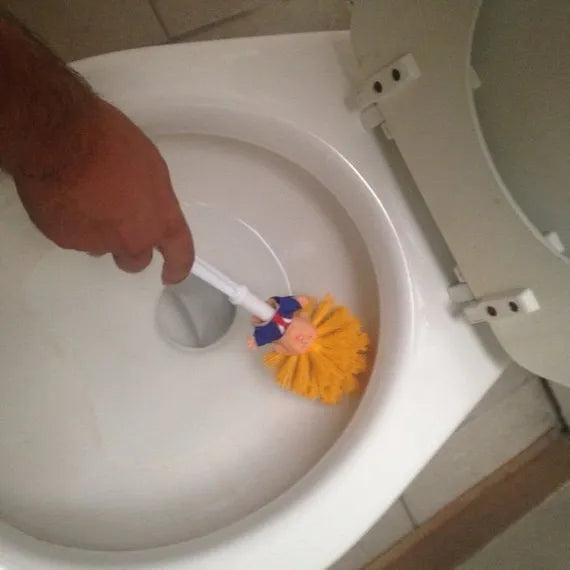 Yellow plastic Trump novelty toilet brush with a hanging slot on the handle.