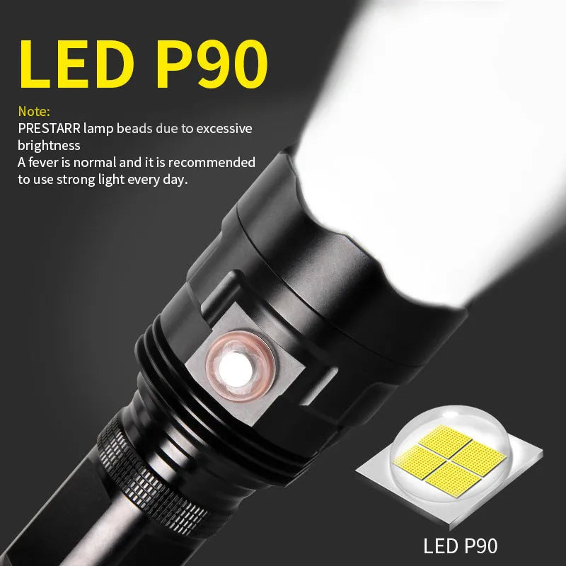 Black aluminium XHP90 LED tactical flashlight showing its size next to a USB charging cable.
