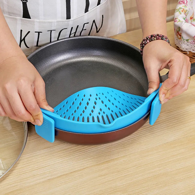 Silicone clip-on kitchen strainer with stainless steel mesh attached to pot rim for draining liquids