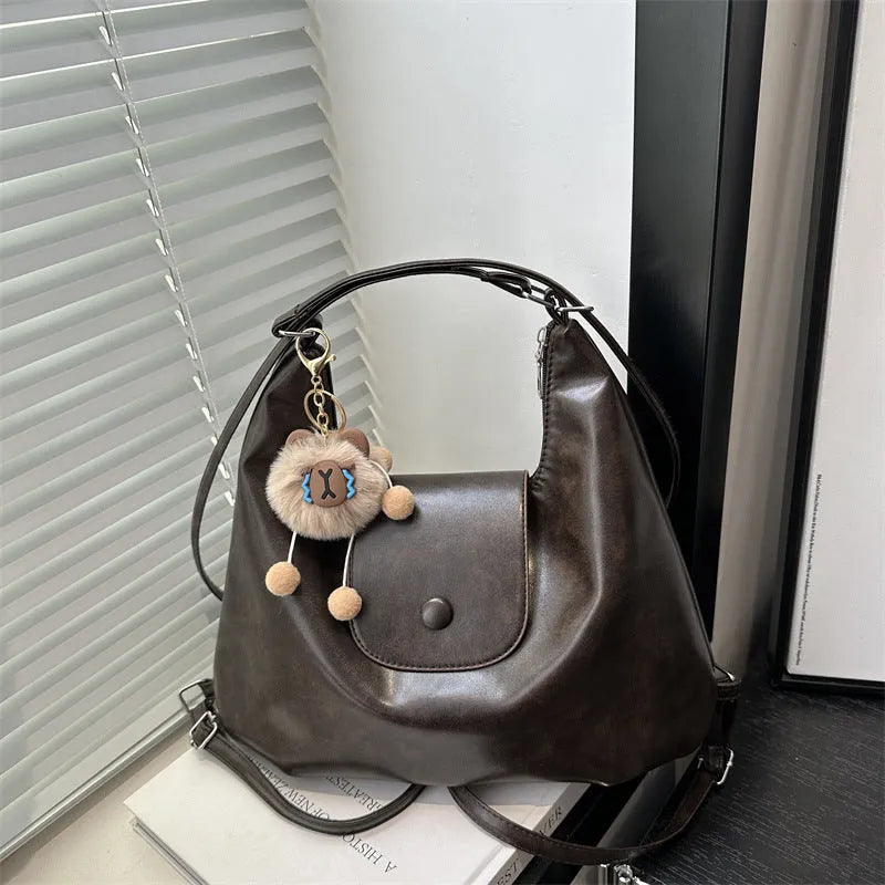 Textured PU leather women's single strap shoulder bag in a horizontal square shape, shown in black colour.