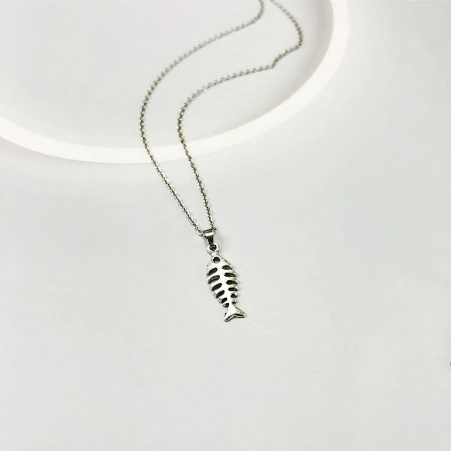 Fishbone pendant necklace with adjustable chain and matching retro earrings set on dark background