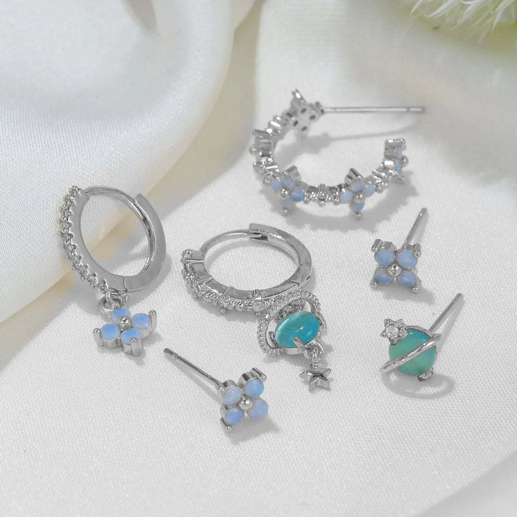 Flower-shaped ear studs with zircon mosaic in gold or silver finish, showing geometric design details