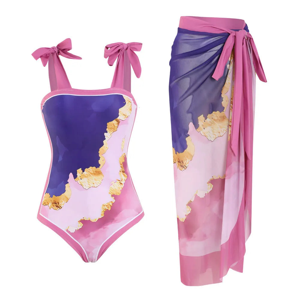 Floral print one-piece swimsuit with mesh tube top and a matching detachable skirt laid flat.