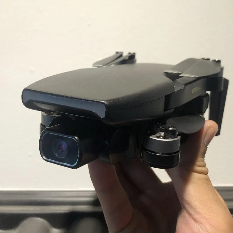 Black folding remote control drone with brushless motor, 4K HD camera, GPS, 4-channel handle remote, and plastic body.