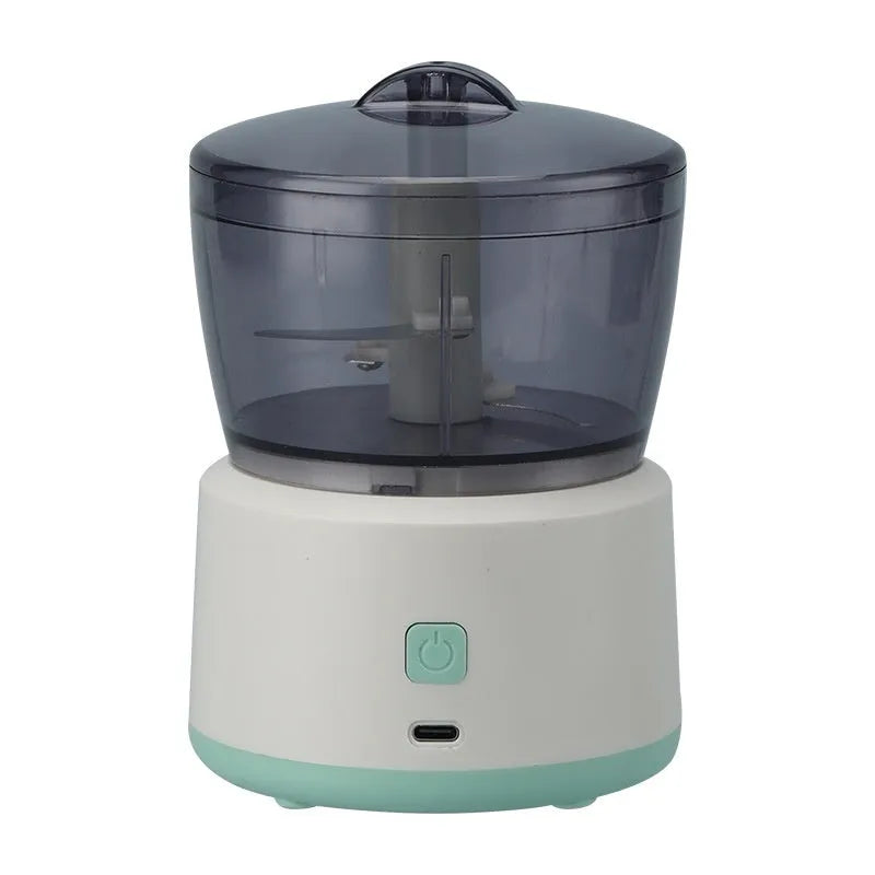 Mini meat grinder with white or light green housing, stainless steel blades, and transparent 225ml cup on anti-slip pad