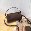 Cylindrical leather crossbody bag for mobile phones in six colours, showing visible sewing thread and compact size.