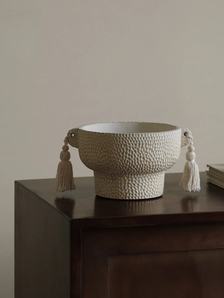 Ceramic binaural planter pot with decorative tassel flower motif on a white background.