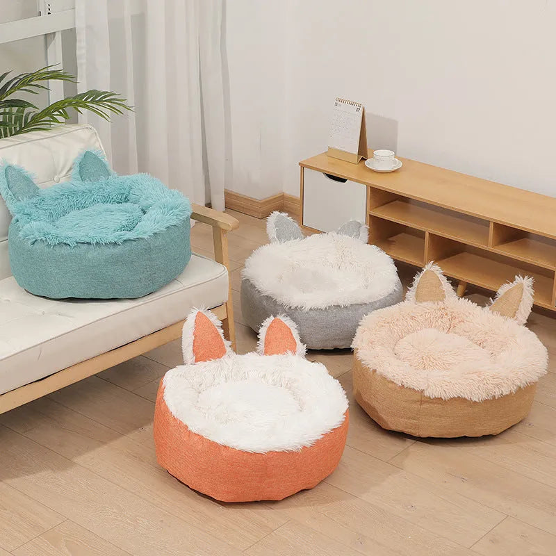 A round soft grey faux fur plush pet bed for cats or small dogs on a wooden floor.