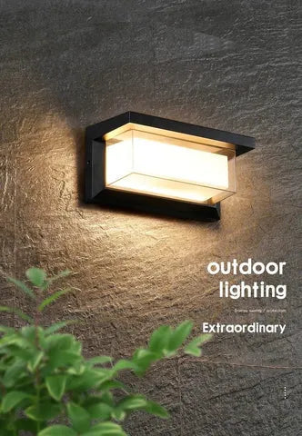 IP65 waterproof outdoor wall lamp with acrylic shade and aluminium body, shown in a garden setting.