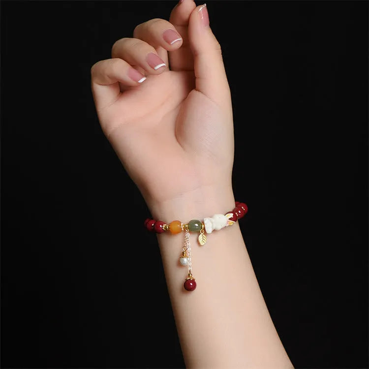 Natural Tian Yu cinnabar bracelet in purple gold sand colour with rabbit design, shown in 8mm and 10mm width options