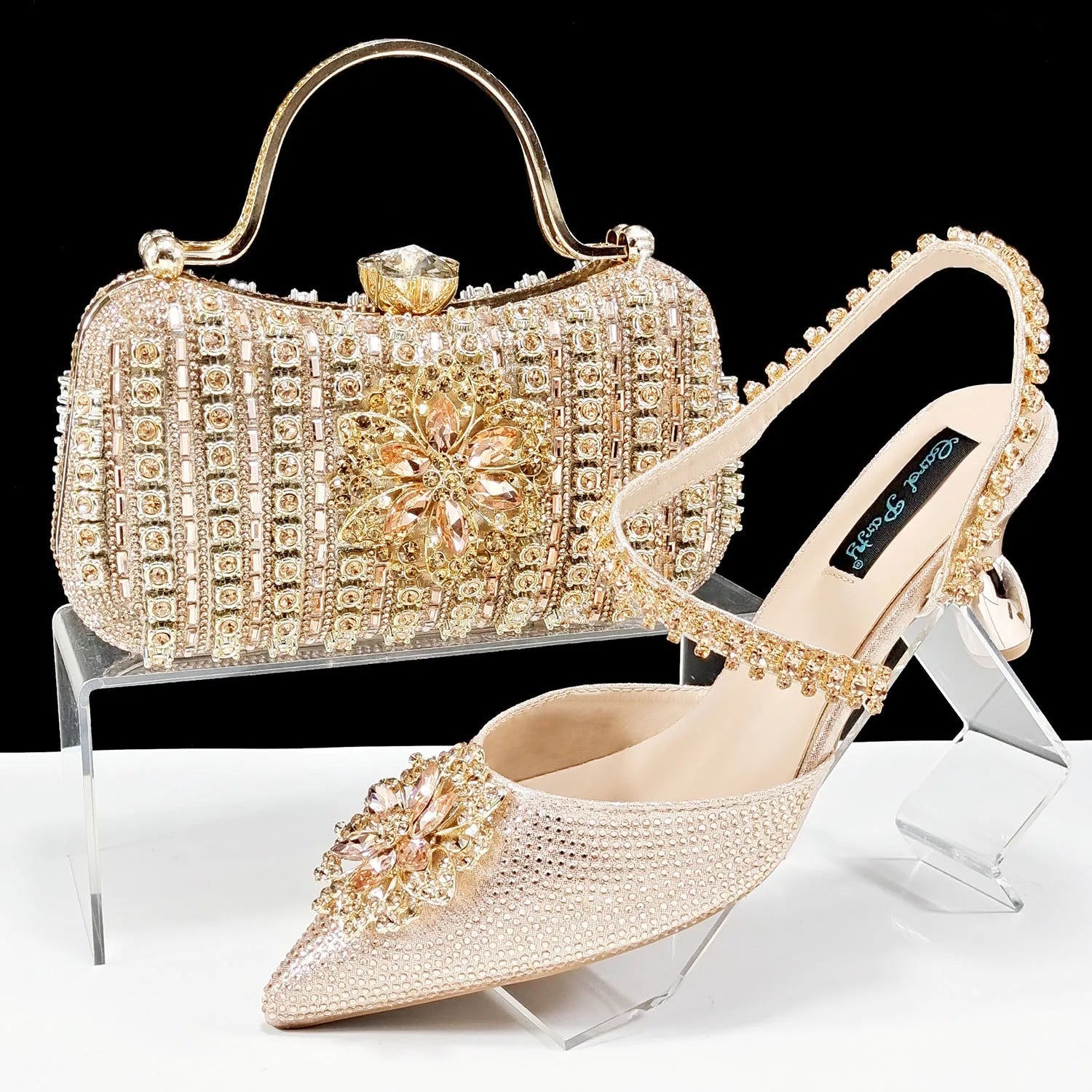 Women's black high-heel shoes with decorative ankle chain featuring floral rhinestone accents and matching clutch bag