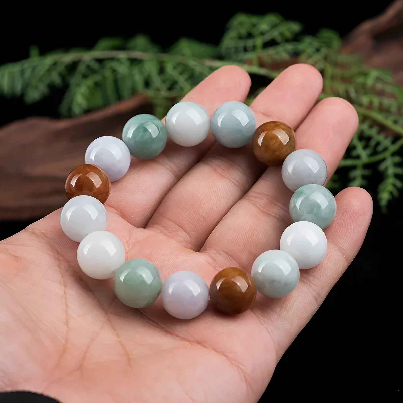 Women's Myanmar jade bracelet with 13mm round beads showing three natural jade colours
