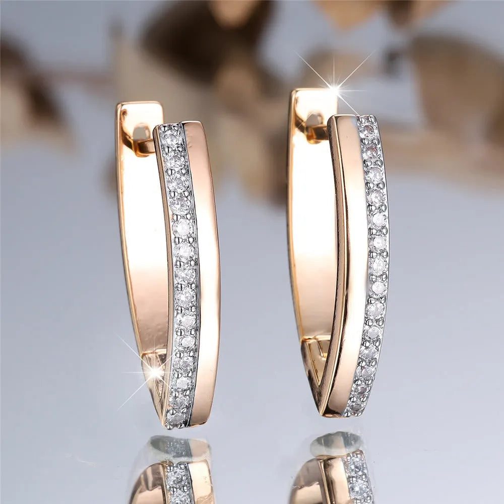 Geometric V-shaped women's ear clips in champagne gold with white diamond accents