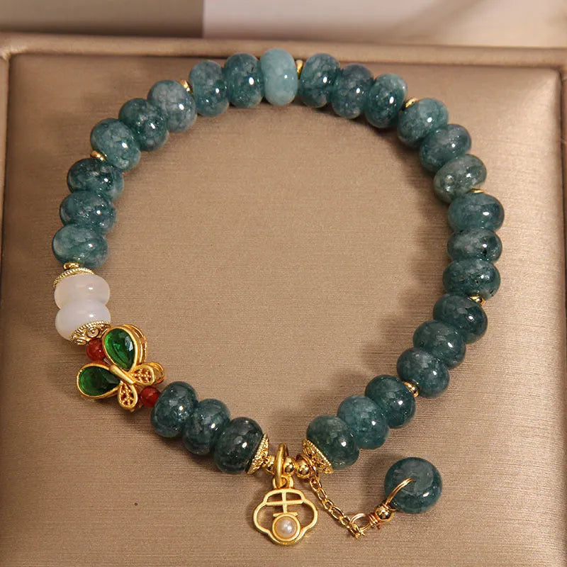Women's blue water jade abacus bead crystal bracelet with butterfly charm and white agate accents