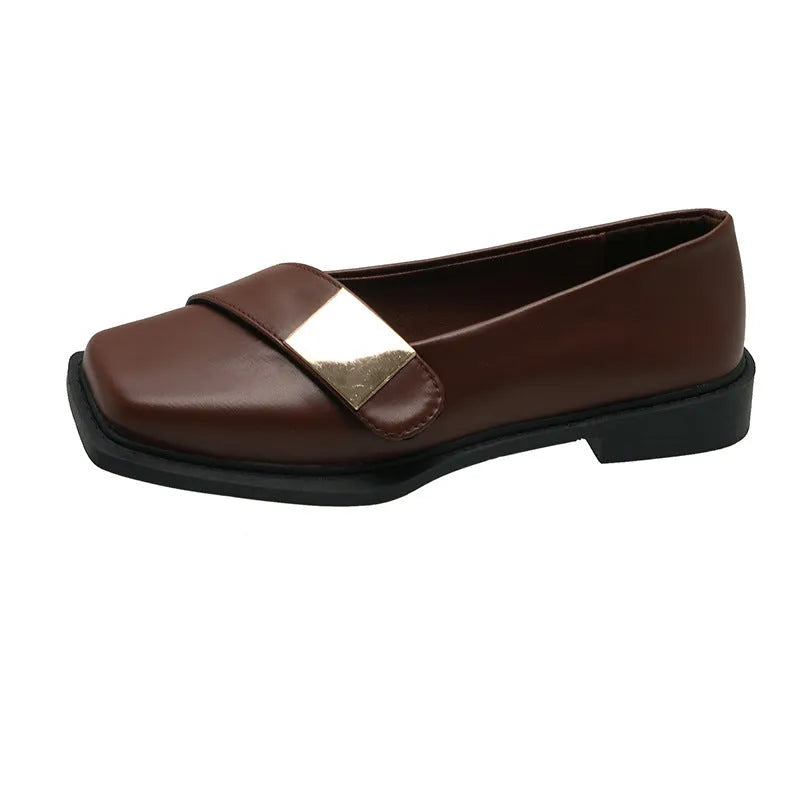 Women's beige square toe flat heel loafers with a silver metal buckle on the upper.