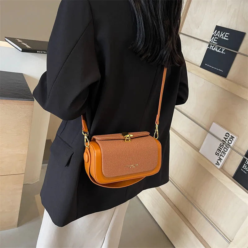 Women's PU leather messenger bag in horizontal square shape with contrast stitching and lock fastening