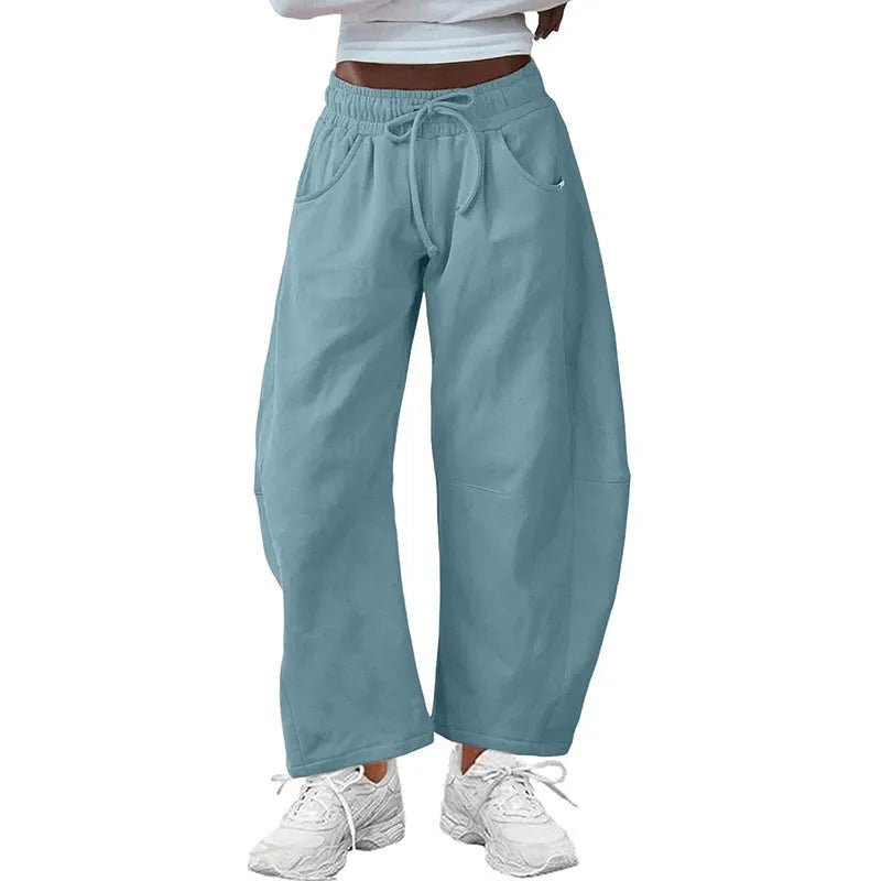 Loose sports cropped sweatpants in hot light grey with elastic waist and drawstring, showing collage/stitching craft details