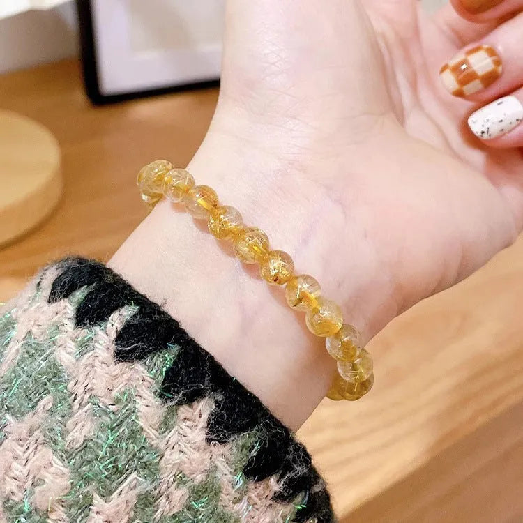 Women's gold rutilated quartz and sunstone crystal bracelet with round beads on elasticated band