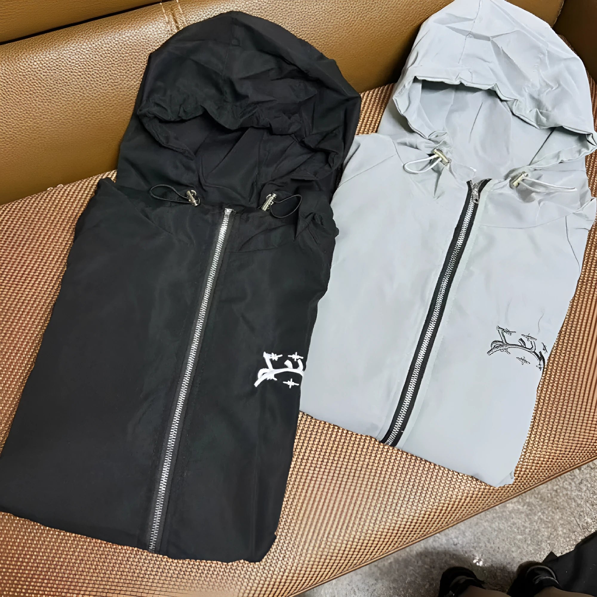 A grey men's hooded loose-fit casual jacket on a hanger.