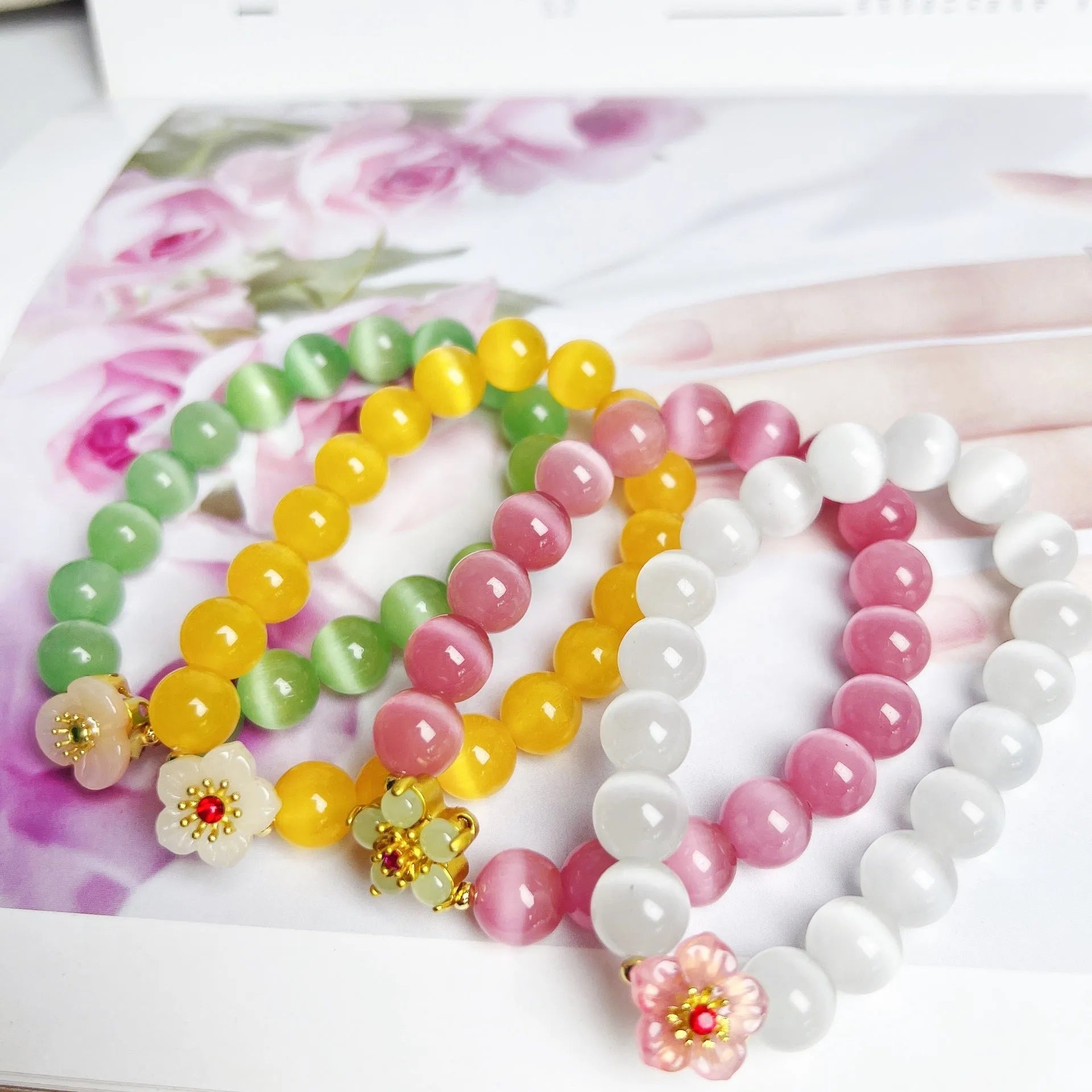 Handmade glass bead bracelet with floral designs in green, pink, white, or yellow colours