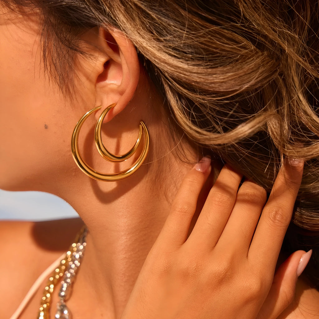 Gold and steel coloured titanium steel hoop earrings for women in large and small sizes.