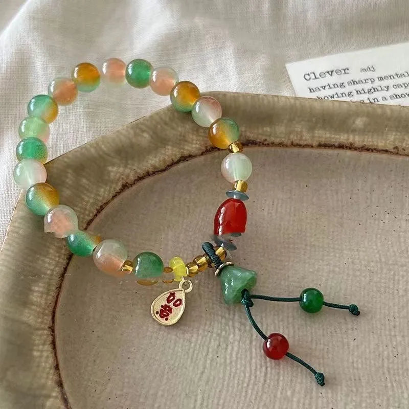 Handmade adjustable bracelet with a detailed lotus charm on a mixed material band.