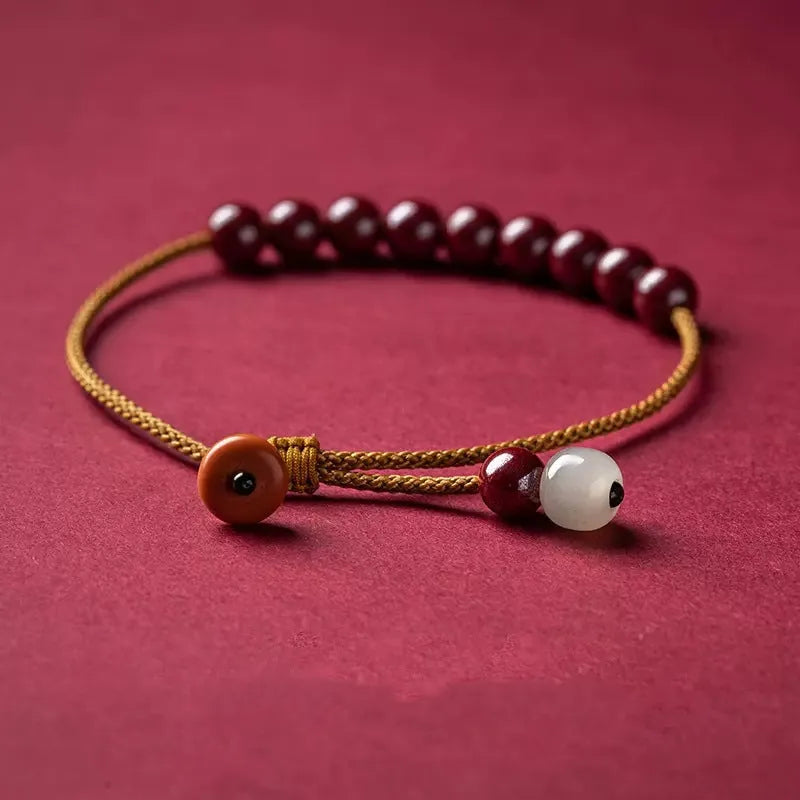 Hand-woven bracelet made from raw cinnabar and Hetian jade beads in a geometric design.