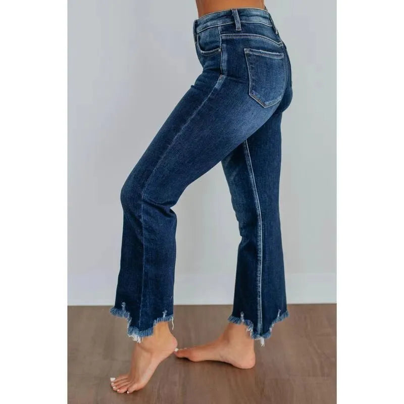 Women's hand-worn denim trousers in dark blue, showing 100% cotton fabric and casual fit