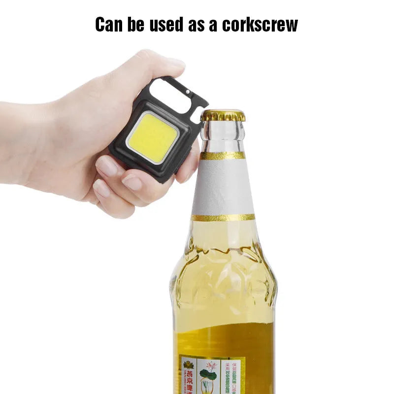 Black aluminium alloy keychain light with magnetic base and foldable handle, measuring 6 cm by 4.2 cm