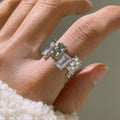 Silver geometric ring with open adjustable band and three-dimensional decoration, shown from multiple angles