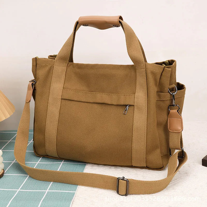 Horizontal square canvas tote bag with side zipper compartments and internal organisation pockets