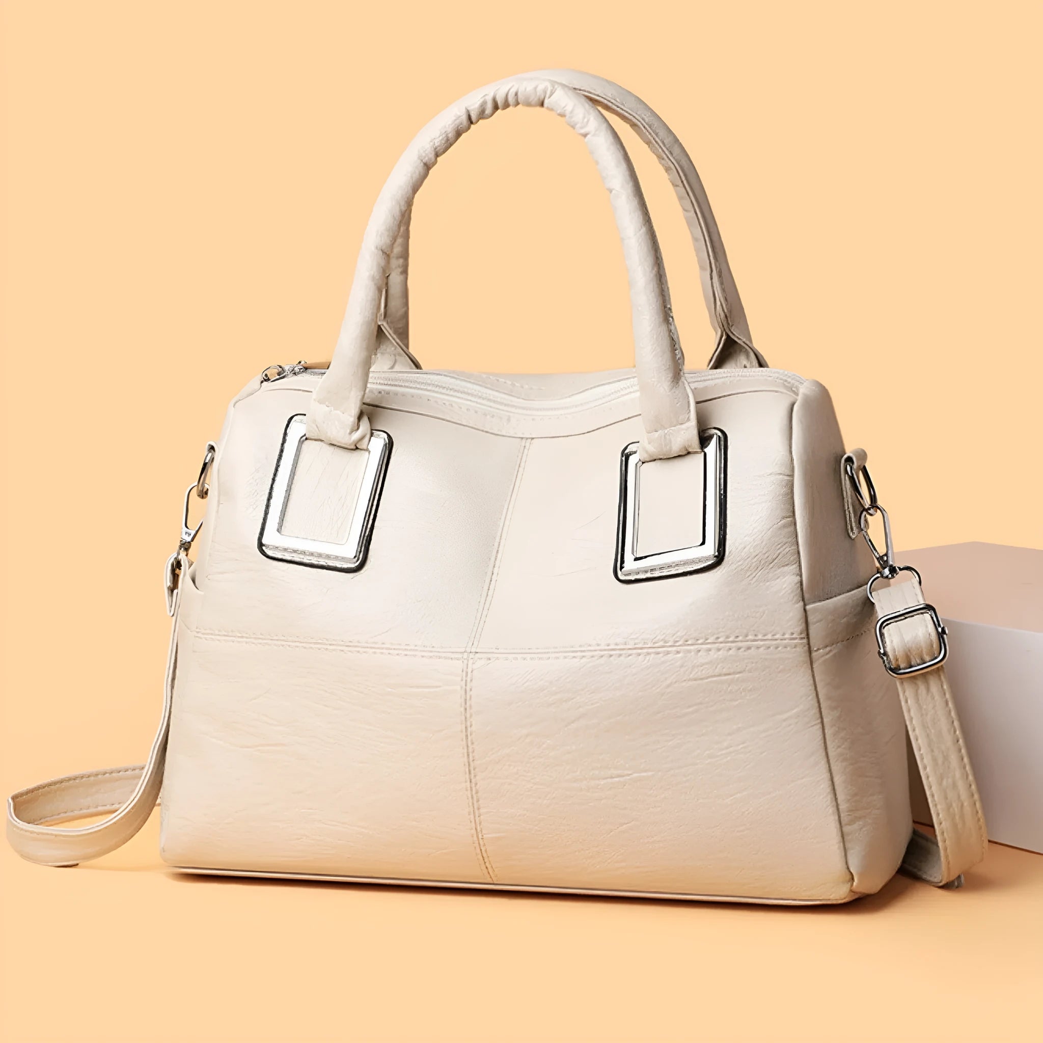 Simple square women's shoulder bag in neutral colour with internal phone and file pockets.