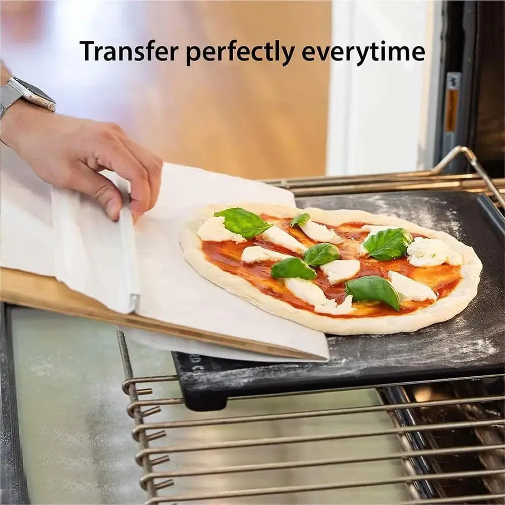 White plastic pizza transfer shovel with handle and hanging hole on a kitchen counter.