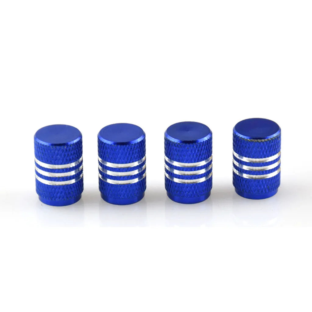 Set of coloured aluminium alloy car tyre valve caps with stainless steel cores on a grey background.