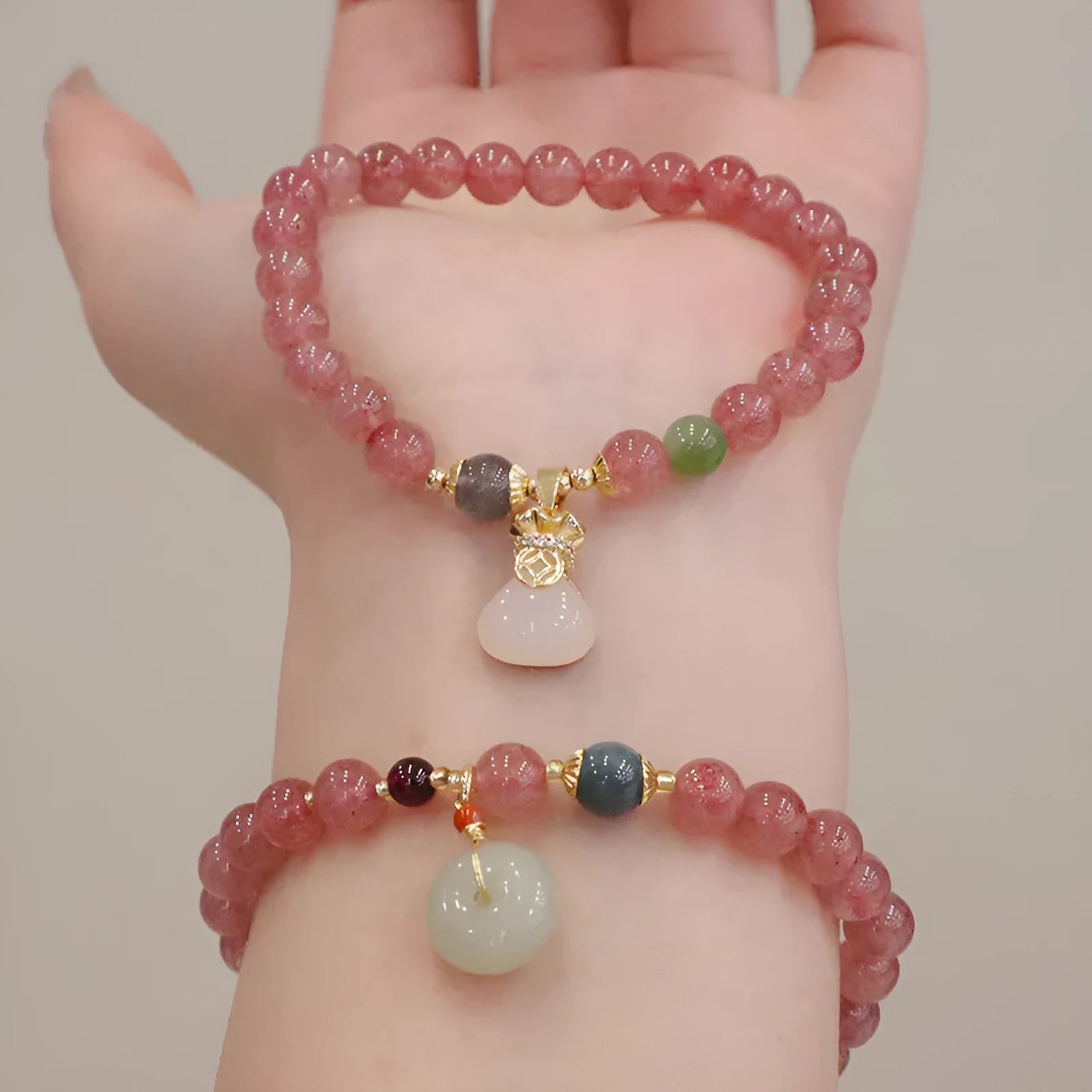 Women's strawberry quartz bracelet with geometric design, purse charm, and safety buckle closure