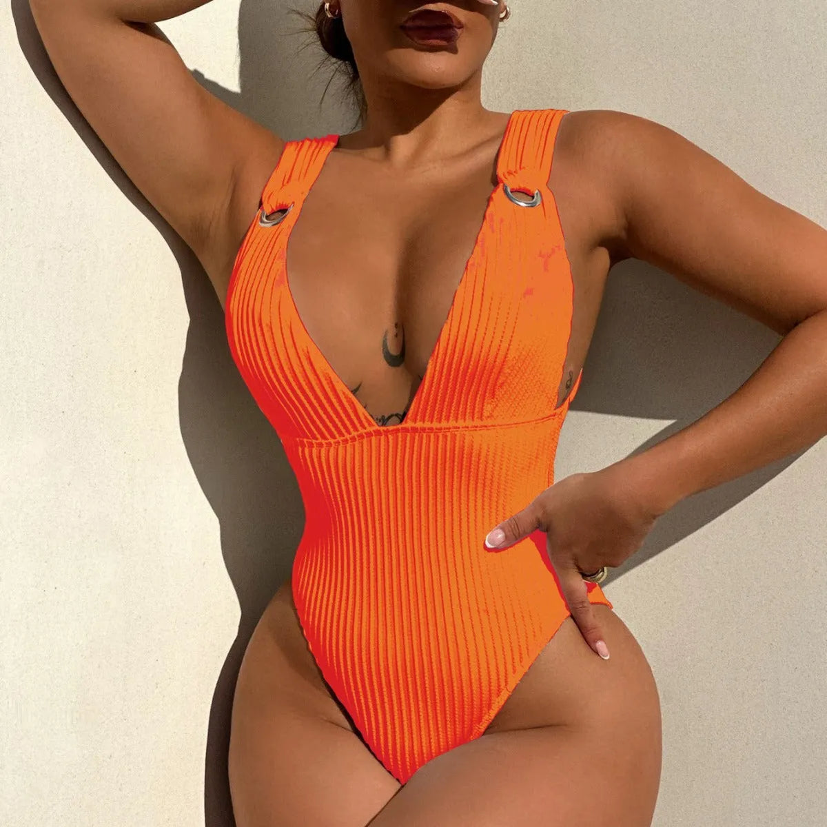 Solid colour one-piece swimsuit for women on a hanger, showing spandex lining and available in black, white, green, orange.