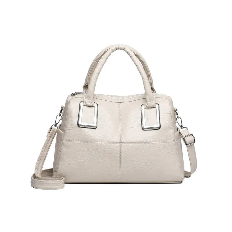 Simple square women's shoulder bag in neutral colour with internal phone and file pockets.