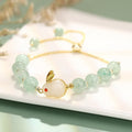 Women's rabbit charm bracelet with green aventurine and strawberry quartz beads, copper and gold details.