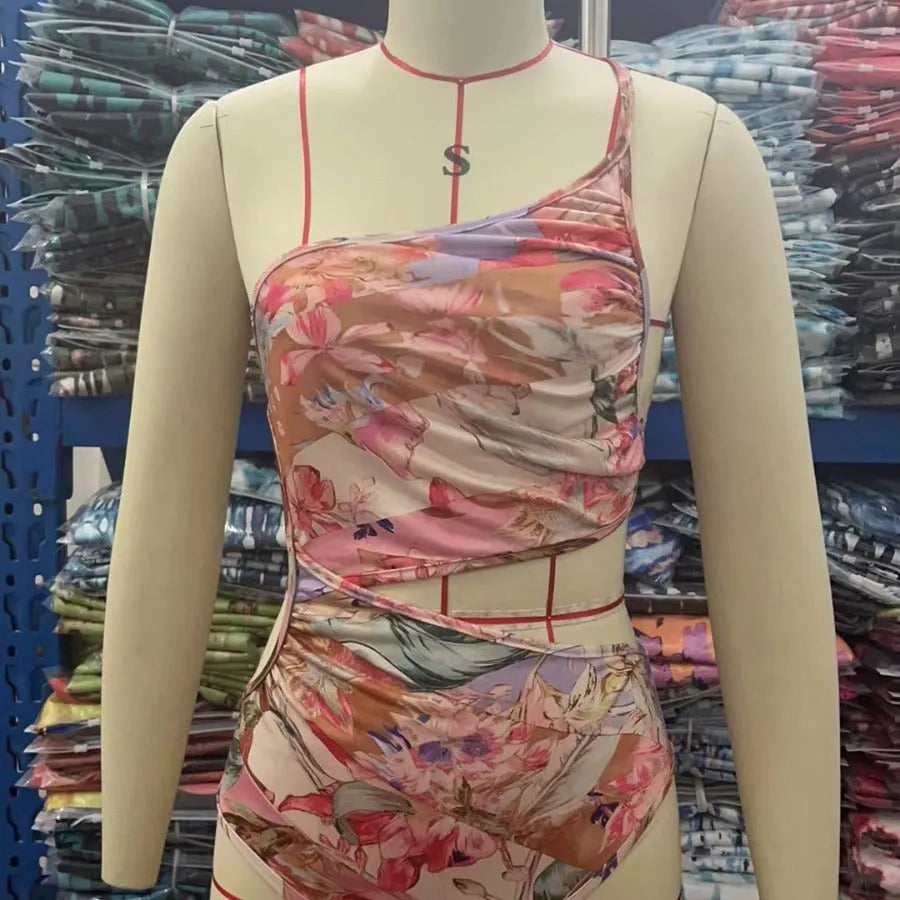 Women's rose gold patterned swimsuit on a hanger.