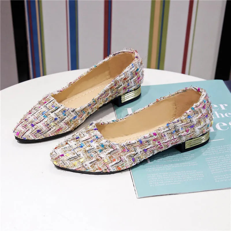Women's black and white floral patterned canvas casual shoes with a pointed toe and flat rubber sole.