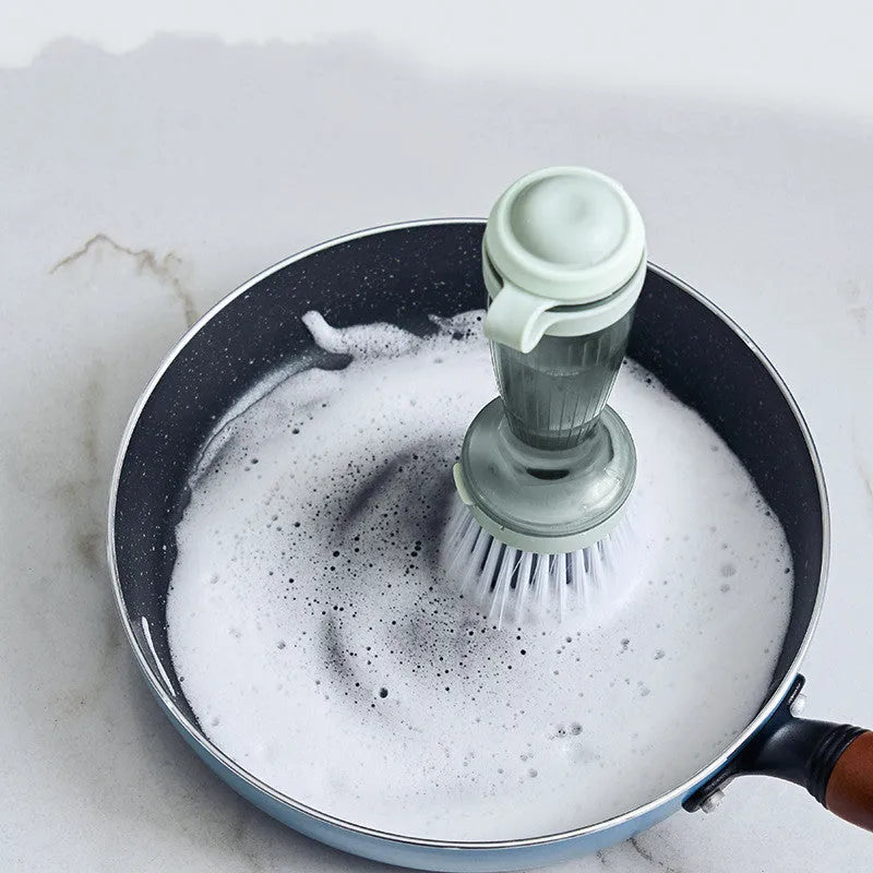 Milk white and mint green kitchen pot brush with soap dispenser in handle and replaceable brush head.