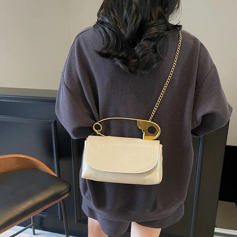 Black street trend shoulder handbag with sandwich pockets and visible sewing thread details.