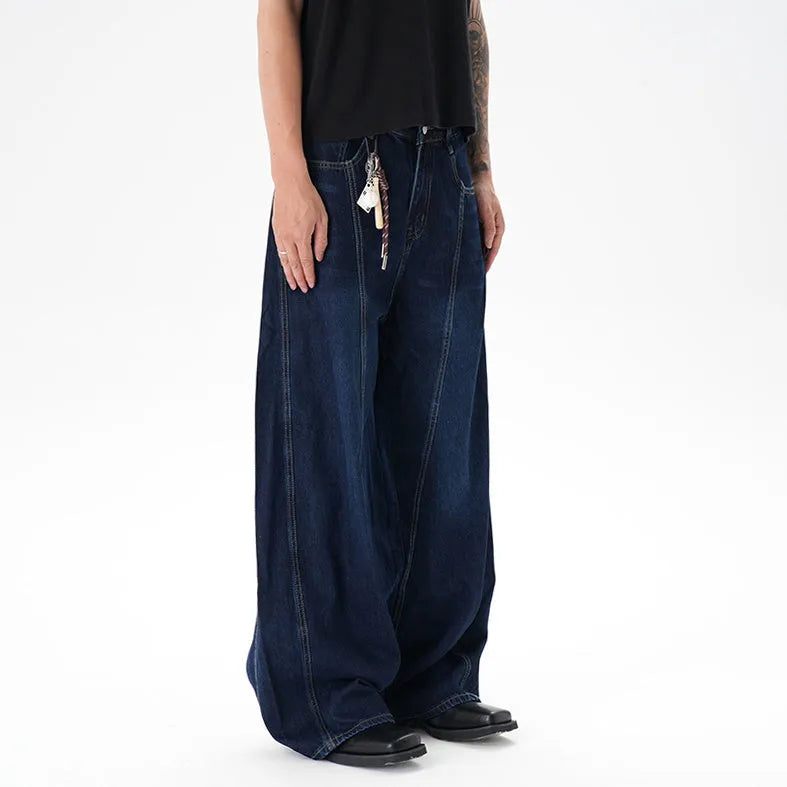 Dark blue wide leg jeans with a distressed wash and machete cut, laid flat.
