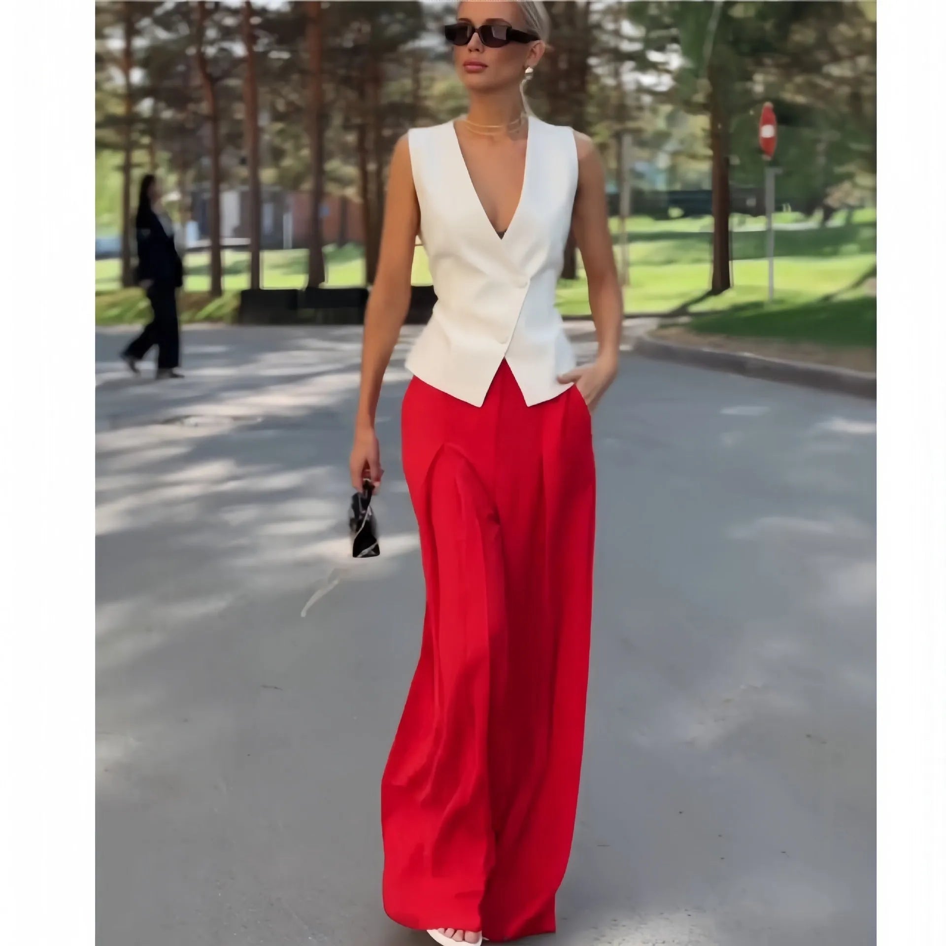 Beige women's sleeveless deep V-neck top and high-waist wide-leg trousers two-piece set on a hanger.