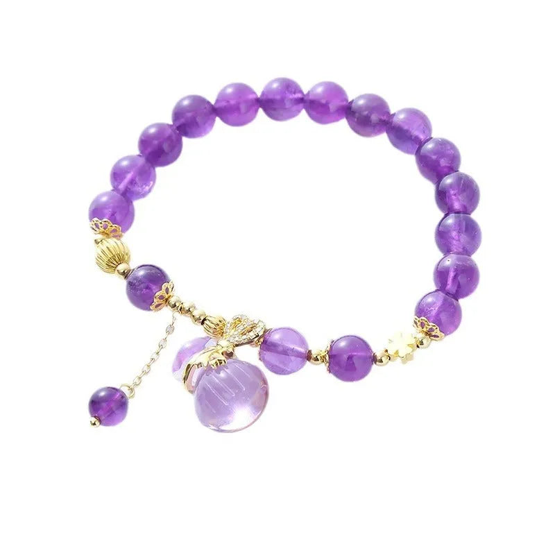 Purple amethyst bracelet with detailed money bag charm and peace buckle pendant on wrist